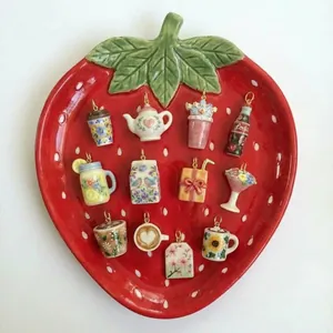 Belle collection de pendentifs en céramique mignons présentés sur une assiette fraise