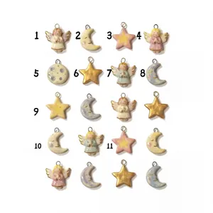 Detailed view of various ceramic angel star and moon pendants with stainless steel loops