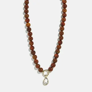 Elegant beaded necklace with brown stones and a clear zircon teardrop pendant