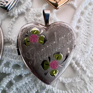 Nahaufnahme eines Vintage-Herzmedaillons mit Blumengravur und Schriftzug 'Grandma'
