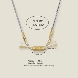 Detailansicht einer bunten Kordelkette mit HAPPY graviertem goldfarbenem Anhänger