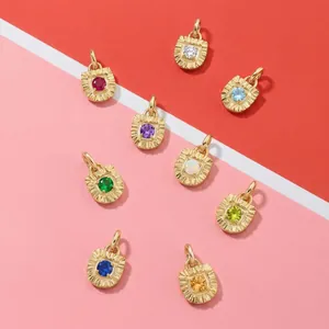 Collezione di nove ciondoli colorati placcati oro con elegante trama a raggi di sole.
