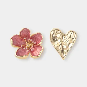 Dettaglio spilla fiore di ciliegio in smalto e cuore in oro martellato