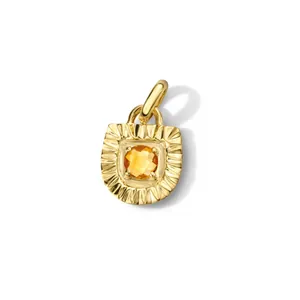Dettaglio di un pendente a raggiera placcato oro con pietra preziosa arancione