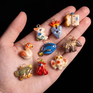 Handheld display of colorful ceramic charms including rabbit, fish, and owl pendants