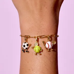 Vue détaillée d'un bracelet doré avec des breloques de football, tennis et baseball
