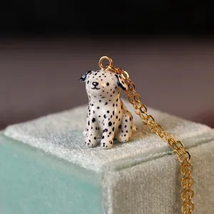 Dettaglio del ciondolo a forma di cane dalmata su un portagioie in velluto azzurro.
