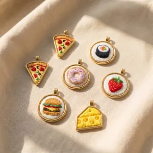 Detailed macro shot of various food-themed embroidery pendants like pizza and sushi.