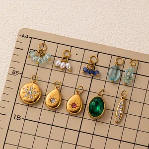 Variété de breloques en acier inoxydable avec pierres sur une planche pour bijoux DIY.