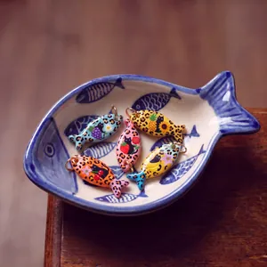 Detailed view of colorful leopard print fish pendants with cute cat and fruit patterns