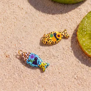Close-up detail of cute fish-shaped jewelry charms with colorful cat and flower patterns