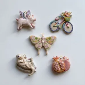 Detail von fünf einzigartigen Keramik-Anhängern: fliegendes Schwein, Motte, Otter.