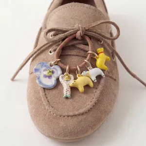 Detail of colorful cute charms like flowers and sea lions hanging on shoelaces.