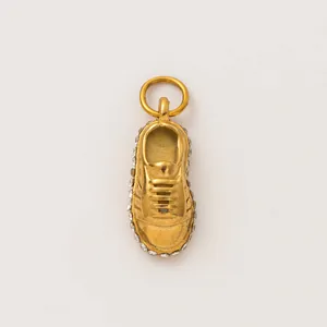 Close-up of golden sneaker charm pendant with sparkling rhinestone details
