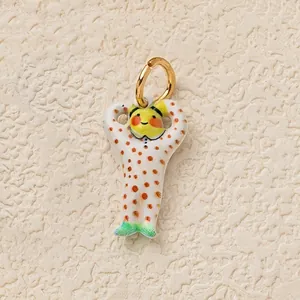 Detailed view of a whimsical colorful character pendant with polka dots and gold ring.