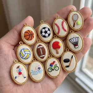 Collection of oval embroidered sports pendants with various athletic icons in gold frames.