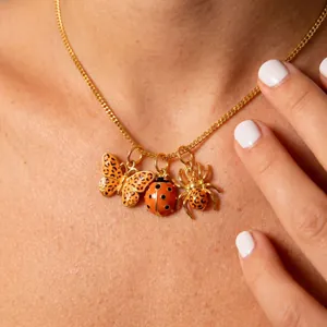 Détail du collier insectes avec papillon léopard, coccinelle et araignée en émail