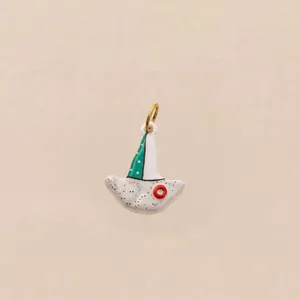 Detailopname van een grillige emaille vogelbedel met groene stippen en een gouden ring