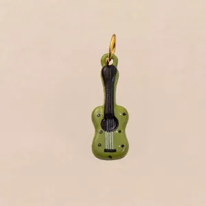 Gedetailleerd beeld van een groene gitaar-schoenbedel met gouden ring.
