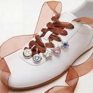 Vue détaillée de breloques de chaussures en acier inoxydable avec motifs étoiles et coeurs