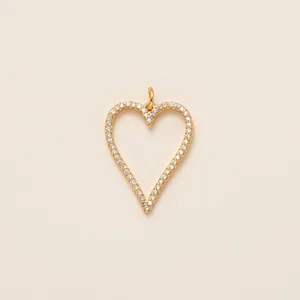 Macro detail of a gold-plated heart-shaped pendant with sparkling white stones.