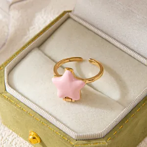 Pink gold star-shaped opening locket ring displayed in a vintage green jewelry box