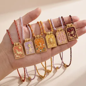 Detail van kleurrijke emaille dierenriemhangers met reliëf op gevlochten koorden