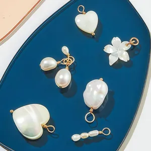 Nahaufnahme von eleganten verschiedenen Perlen- und Muschel-Anhängern für DIY-Schmuck