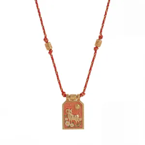 Detail van Ram sterrenbeeld emaille plaquette ketting met rood gevlochten koord.