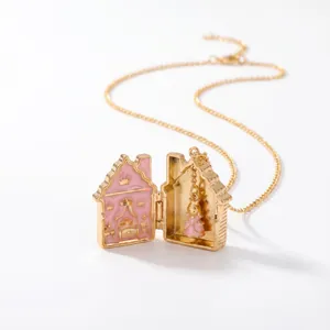Detailansicht einer goldenen Märchen-Lebkuchenhaus-Medaillon-Halskette mit rosa Emaille