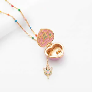 Vintage style heart locket necklace with miniature house interior and fairy charm.