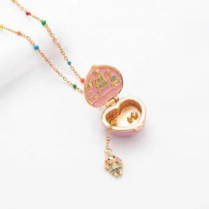 Detailed view of pink heart locket necklace with miniature house interior and bunny charm