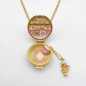 Detalle de collar relicario que muestra una escena de cocina en esmalte y muñeca de chef