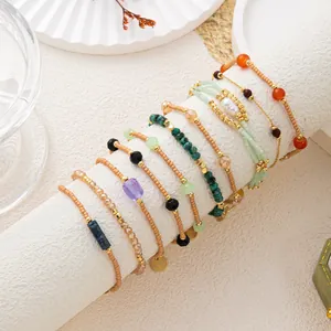 Detailansicht eines mehrschichtigen Vintage-Armbandsets mit Natursteinen und Metallketten.