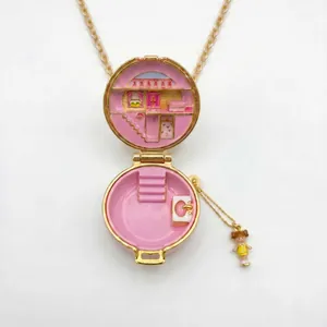Detalle del collar de guardapelo de esmalte dorado con escena de casa de muñecas en miniatura