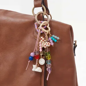 Macro detail of a colorful DIY bag charm with butterfly, cat, and heart beads