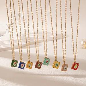 Detailed view of various vintage hand-painted book pendant necklaces in stainless steel