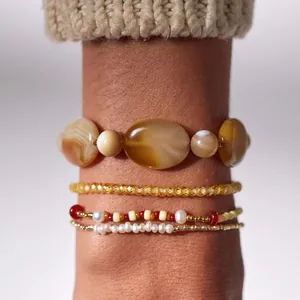 Gros plan détaillé de bracelets en perles superposés avec des pierres d'agate et des perles.