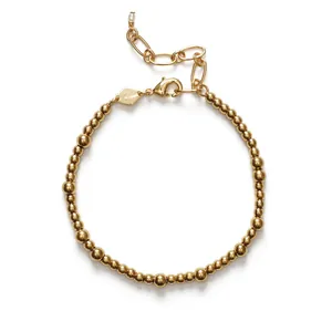 Vue détaillée d'un bracelet minimaliste en perles dorées avec un charm en perle fine