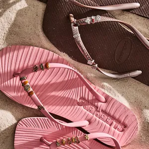 Gros plan détaillé de charms DIY colorés pour chaussures sur tongs roses et brunes
