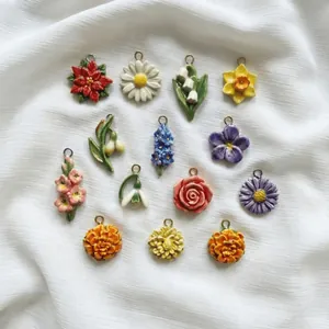 Colorful stainless steel floral pendants in various flower shapes on white fabric