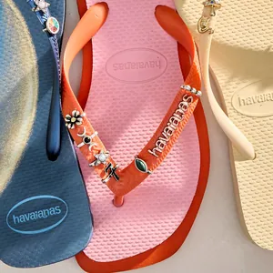 Vue macro de breloques de chaussures en métal DIY tendance sur des tongs d'été colorées