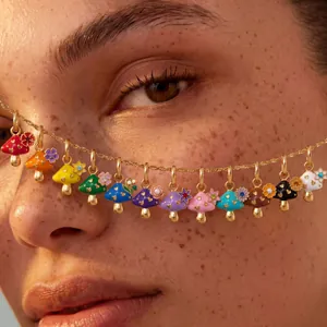 Close-up detail of various colorful enamel mushroom pendants on a delicate gold chain.