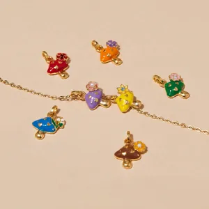 Detailed view of colorful enamel mushroom pendants with delicate floral accents