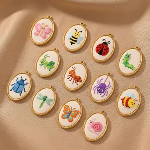 Detailed macro view of various oval stainless steel pendants with embroidered insect patterns