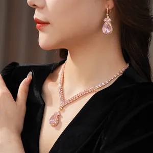 Close-up of elegant luxury pink teardrop gemstone necklace and matching earring set on model