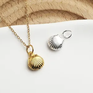 Gros plan détaillé de pendentifs coquillage en argent S990 poli en finitions or et argent