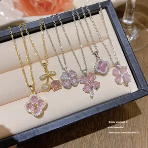 Gros plan de pendentifs trèfle et cerise en zircon rose dans un coffret à bijoux