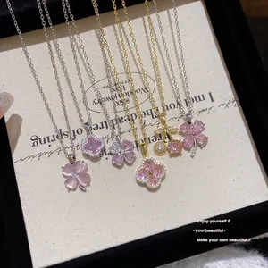 Collection de pendentifs trèfle et cerise en zircon rose sur un présentoir bijoux