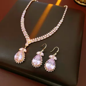 Close-up of luxurious pink pear-shaped crystal necklace and earrings jewelry set.